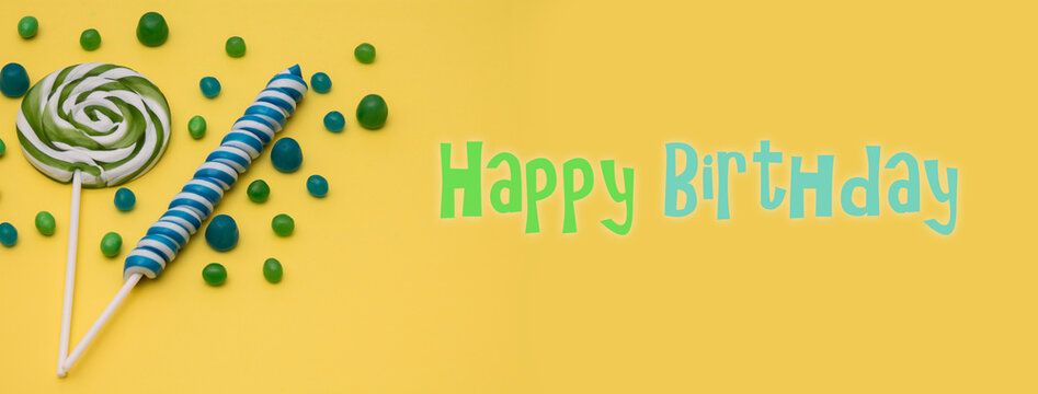 spiral lollipop on yellow background with happy birthday text