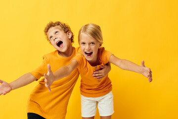 Portrait of cute children cuddling fashion childhood entertainment yellow background unaltered