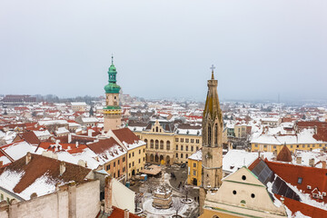 Aerial view about the main square of Sopron with the Fire tower and Goat Church. Winter cityscape with snowy rooftops.