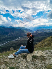 A girl on the background of a breathtaking view of the mountains in Dagestan, Caucasus. Russia 2021