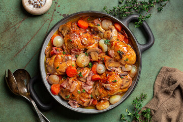 French dish of chicken braised with red wine, lardons, mushrooms, carrot and onion. Coq au vin or...