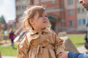 The concept of protection against child abduction. The kid stands next to a man who holds out his hand to him.
