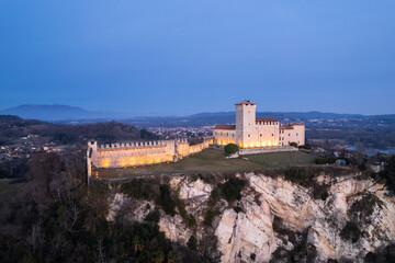Close up aerial view of Rocca Borromea of Angera city, Varese lightened up at blue hour.