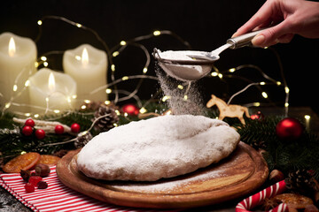 Traditional Christmass stollen cake with marzipan and dried fruit on rustic background
