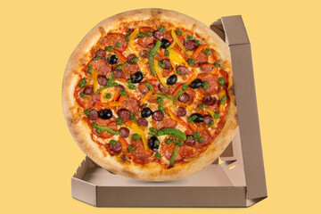 italian pizza with ham and sausages, in an open box, on a yellow background