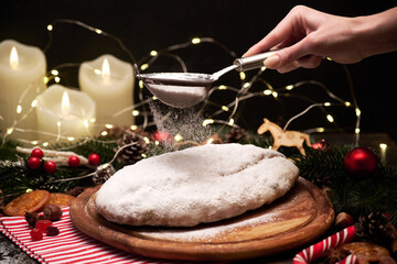 Traditional Christmass stollen cake with marzipan and dried fruit on rustic background