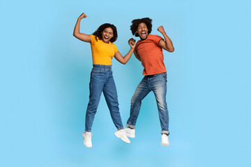 Funny african american millennials showing muscles on blue