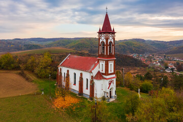 Soshartyan, Hungary - Aerial view about a Roman Catholic Church named Heart of Jesus. Autumn landscape with cloudy sky.