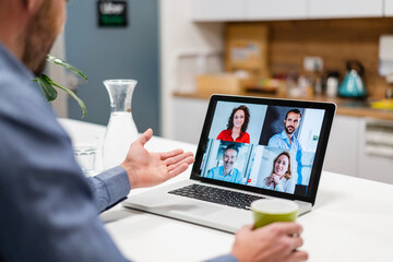 Businessman discussing with colleagues in web conference at home office