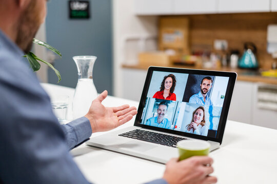 Businessman discussing with colleagues in web conference at home office