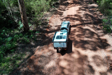 Aerial landscape view of off road vehicle towing a caravan - obrazy, fototapety, plakaty