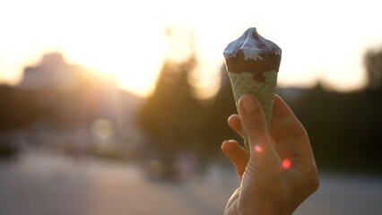 Ice Cream Melting In female Hand Outdoors in summer bright day. Food And Travel Concept.