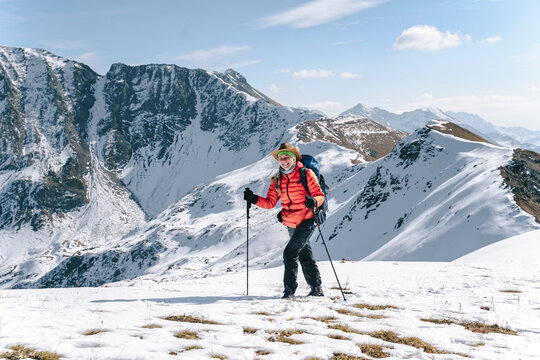 Happy woman hiking on snow covered mountain, Caucasus Nature Reserve, Sochi, Russia
