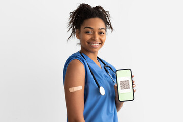 Black doctor showing adhesive plaster on arm and digital certificate