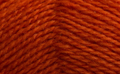 Woolen, fluffy white knitting threads are wound into a ball. Soft, warm background. Close-up.