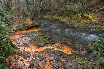 superbe ruisseau d'eau ferrugineuse rouge se jetant dans la rivière Couze dans le Puy de dôme