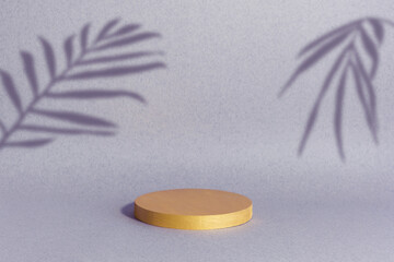 Minimal abstract background for the presentation of a cosmetic product. Golden scene on a lilac background with a shadow of tropical palm leaves. Premium podium, showcase, display case.