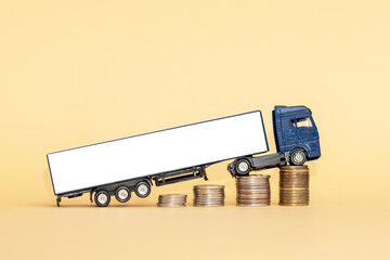 A model of a truck with a trailer and coins are located on a yellow background. Increasing the cost...