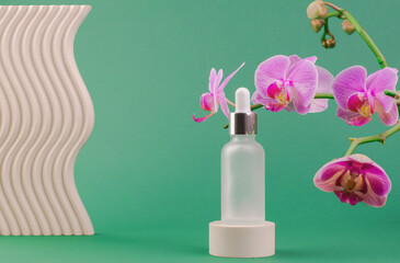 White bottles with essential oils or serum with orchid flowers on a green background. Care and beauty concept
