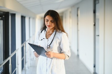 An Indian Asian female medical doctor in a hospital office with stethoscope.