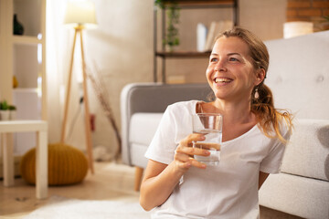 Girl holding a glass of water. Smiling girl drinking water..