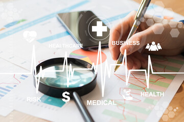 Businessman checks business healthcare statistics on virtual screen in office. Medical business analysis concept.