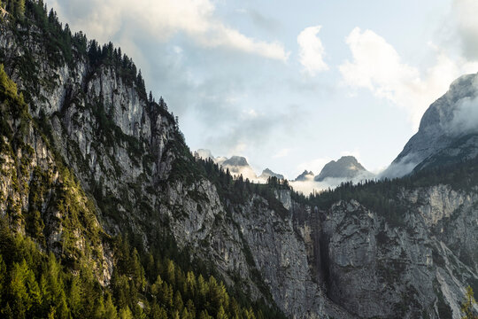 Steep cliffs of Mieming Range in summer with Seeben waterfall in background