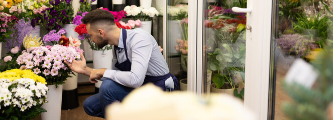 flower center worker in the refrigerator with fresh bouquets