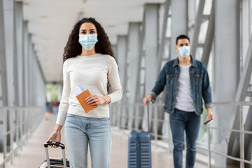New Normal. Young Man And Woman Wearing Medical Masks Walking At Airport