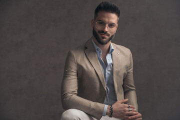 confident businessman with glasses smiling and rubbing palms and fingers