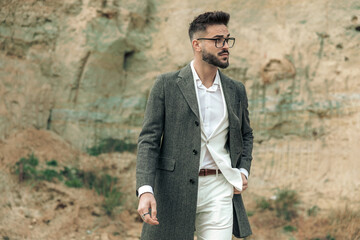 sexy handsome guy with glasses holding hand in pocket and looking to side