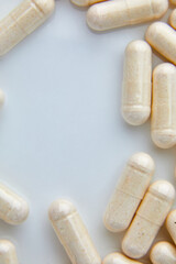 Flat lay macro White beige capsule pills, tablets, top view, close up texture background pharmaceutical industry concept, copy space.