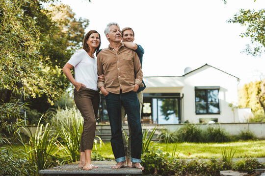 Happy family standing together in garden - Powered by Adobe