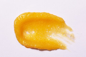 Mango or orange body scrub swatch isolated on white. Beauty skincare product smear. Flat lay.
