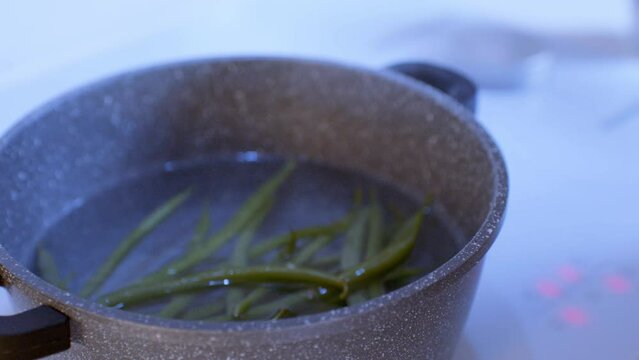 Cooking on the stove. Green beans in the boiling water, salted