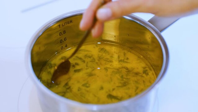 Cooking soup on the stove. The sauce in the steel pot