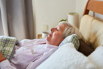 Old woman taking a nap or as a patient at home