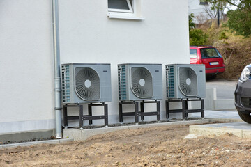 Klimaanlage/Luftwärmepumpe vor einem neu erbauten Wohnhaus