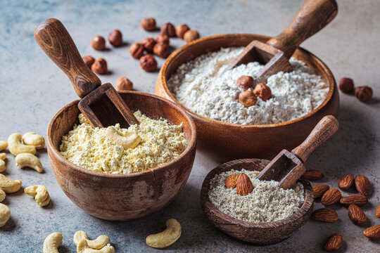 Different types of nut flour - almond, hazelnut and cashew, dark background. Keto diet and gluten free concept.
