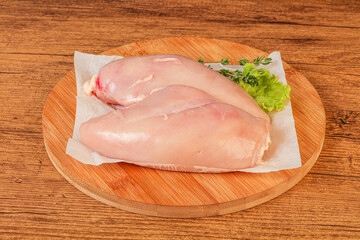 Raw chicken breast over board