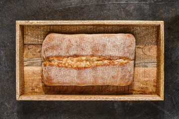 Italian ciabatta bread  in a wooden box. Freshly baked traditional bread. Shallow depth of field, top view