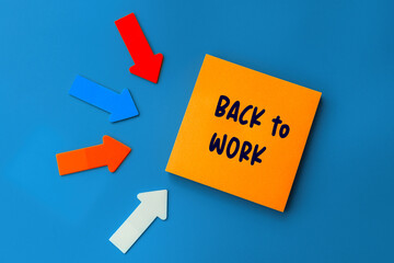 Back to work - concept of text on sticky note. Orange square sticky note and colorful arrows on blue background, top view