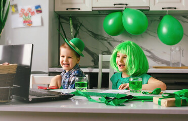 Children communicate online via a laptop on the Patrick's Day holiday. Traditions, technologies,...