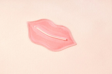 Pink hydrogel lips patch on beige background. Korean cosmetics. Cosmetology and skin care. 
