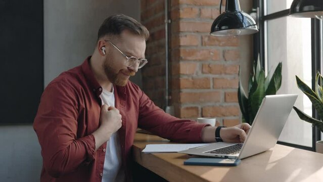 Handsome programer typing at the laptop keyboard and coughing while working at the cafe. Sick freelancer feeling bad during his working day. Illness concept