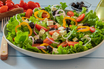 green salad with vegetables and feta in a plate on a table