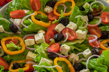green salad with vegetables and feta in a plate on a table