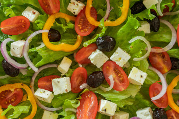 green salad with vegetables and feta in a plate on a table