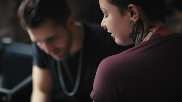 Caucasian man and woman discussing about new tattoos. Shot with RED helium camera in 8K.