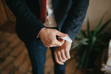 Young handsome man in classic suit. Young businessman puts on suit and prepares for a meeting.
